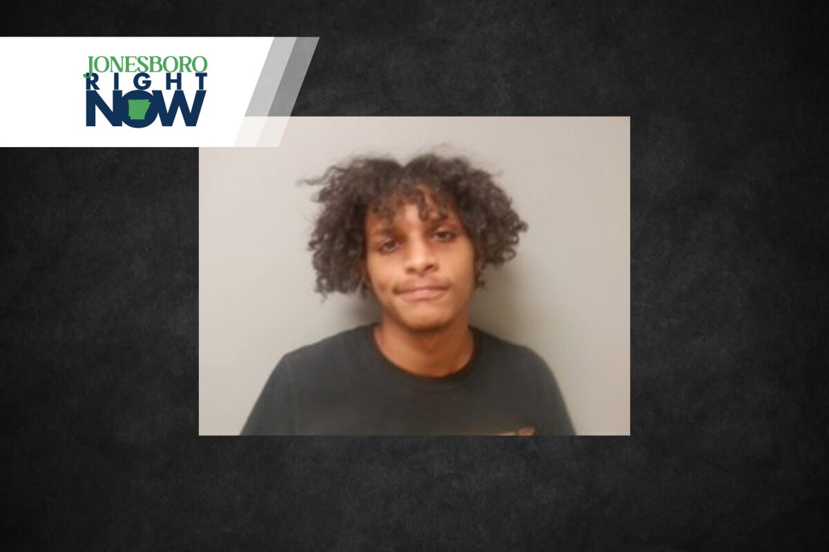 Young man with curly hair wearing a black shirt against a gray wall; Jonesboro Right Now banner in the top-left corner.