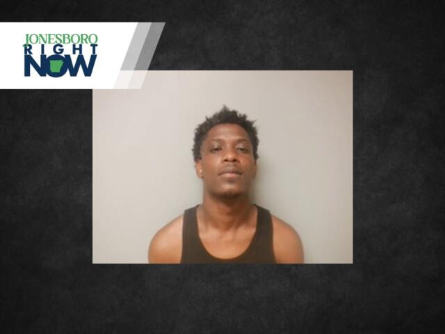 Mugshot-style photo of a young man in a black tank top against a gray wall, with a Jonesboro Right Now logo in the upper left corner.