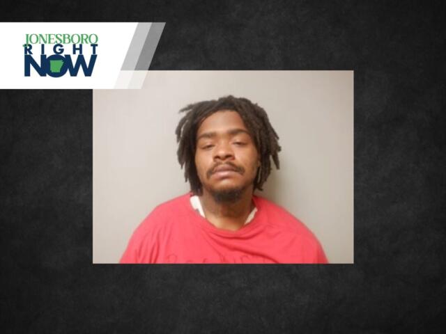 Mugshot-style photo of a man with dreadlocks wearing a red shirt, neutral background, Jonesboro Light Now logo in the top-left corner.