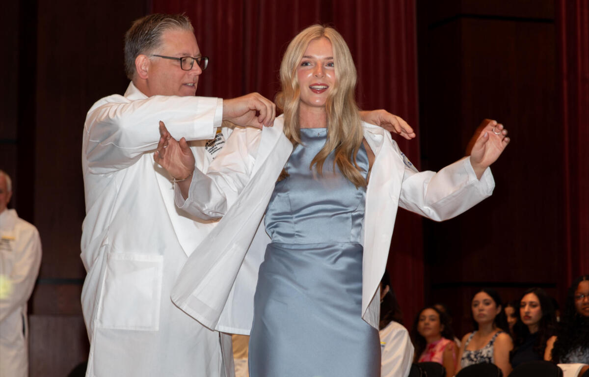 Allison Shinabery, a Jonesboro native and incoming first-year medical student at NYIT College of Osteopathic Medicine at Arkansas State University, is coated by Dr. Steven Lewis, NYITCOM at A-State's associate dean of academic affairs.