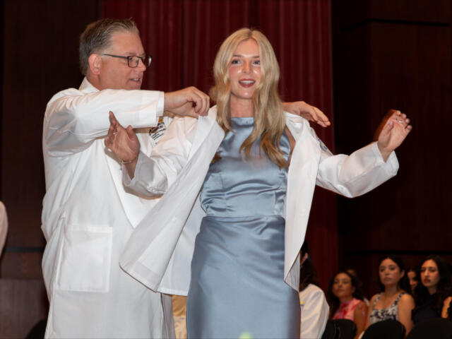 Allison Shinabery, a Jonesboro native and incoming first-year medical student at NYIT College of Osteopathic Medicine at Arkansas State University, is coated by Dr. Steven Lewis, NYITCOM at A-State's associate dean of academic affairs.